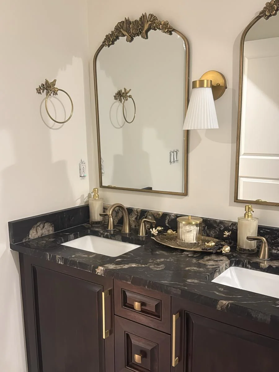 Bathroom double vanity refinished in a deep espresso finish with brass hardware and a dark stone countertop